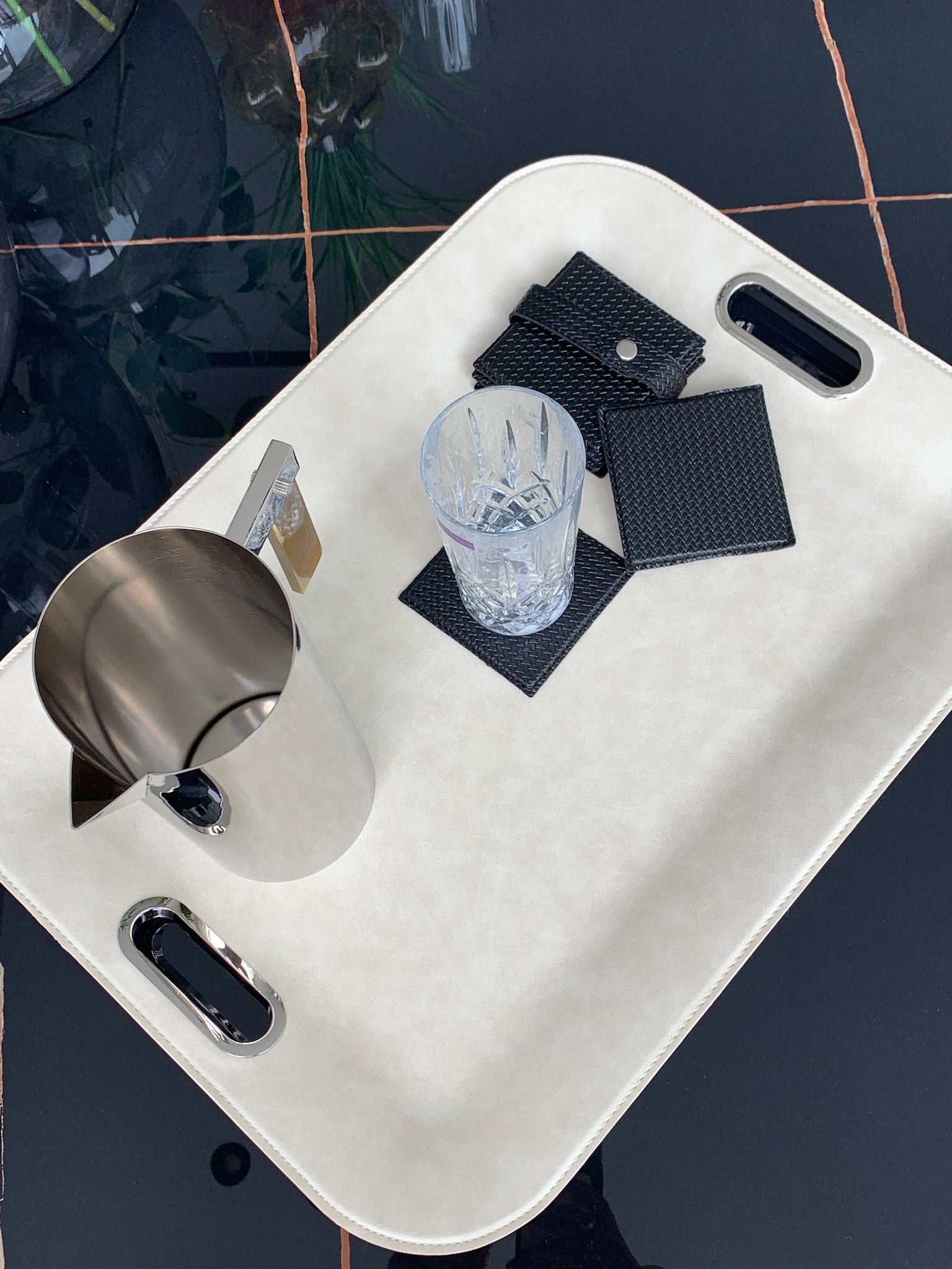 large  Ivoery serving tray with metal handles set with glassware for entertaining and coasters